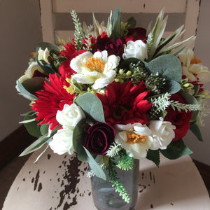 An arrangement of red and ivory flowers
