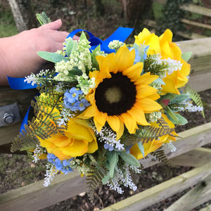 a brides bouquet of sunflowers roses and blue forget-me-nots