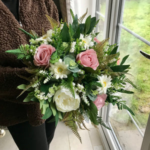 A wedding bouquet featuring dusky pink gerbera and roses