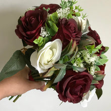 An artificial wedding bouquet of ivory and burgundy roses