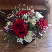 a flower arrangement of red & ivory roses