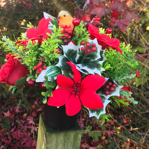 a christmas grave memorial pot with red artificial flower arrangement