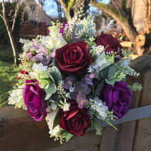 A wedding bouquet of artificial ivory & purple flowers
