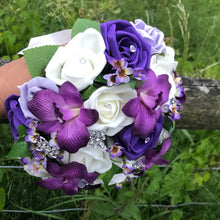 A brides wedding bouquet of artificial ivory & purple flowers