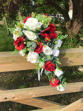 A teardrop bouquet collection of white and red roses and anenomies