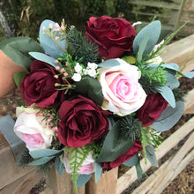 A Christmas bouquet of artificial pink and burgundy roses