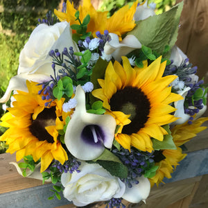 A wedding bouquet featuring calla lilies, roses & sunflowers