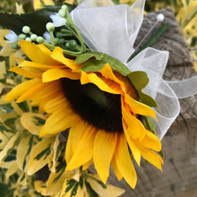 A buttonhole featuring a yellow sunflower & gyp