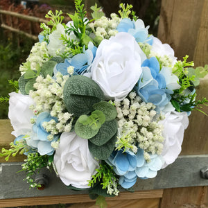 A wedding bouquet collection featuring ivory/white and pale blue flowe ...