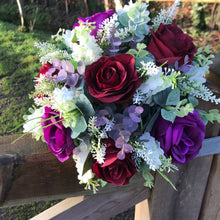 A wedding bouquet of artificial ivory & purple flowers