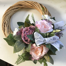 A wicker wreath featuring artificial flowers