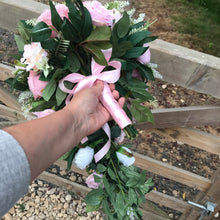 A teardrop bouquet of artificial pink and white roses