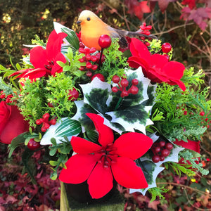 a christmas grave memorial pot with red artificial flower arrangement