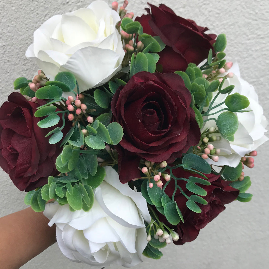 an artificial wedding bouquet of burgundy and ivory flowers