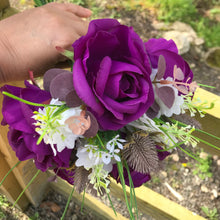 A collection of wedding bouquets featuring  artificial purple rose flowers & thistles