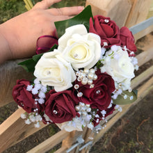 A wedding bouquet of artificial ivory & burgundy rose flowers