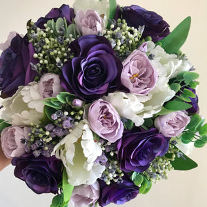 A brides bouquet of purple, lilac and ivory silk roses & tulips