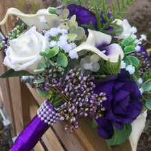 A wedding bouquet of ivory and purple silk flowers