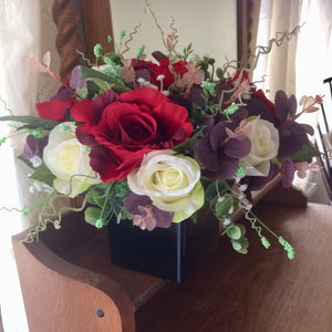 a flower arrangement of red & ivory roses