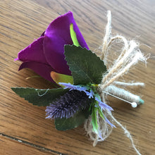 A wedding buttonhole featuring a rose and thistle head