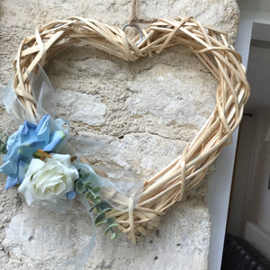 A wicker wreath with blue flower arrangement