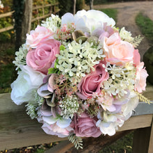 A wedding bouquet of ivory and dusky pink artificial flowers