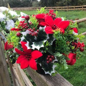 a christmas grave memorial pot with red artificial flower arrangement