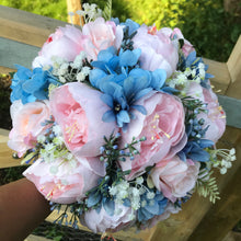 A wedding bouquet of pale pink and blue flowers