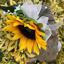 A buttonhole featuring a yellow sunflower & gyp