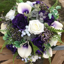 A wedding bouquet of ivory and purple silk flowers