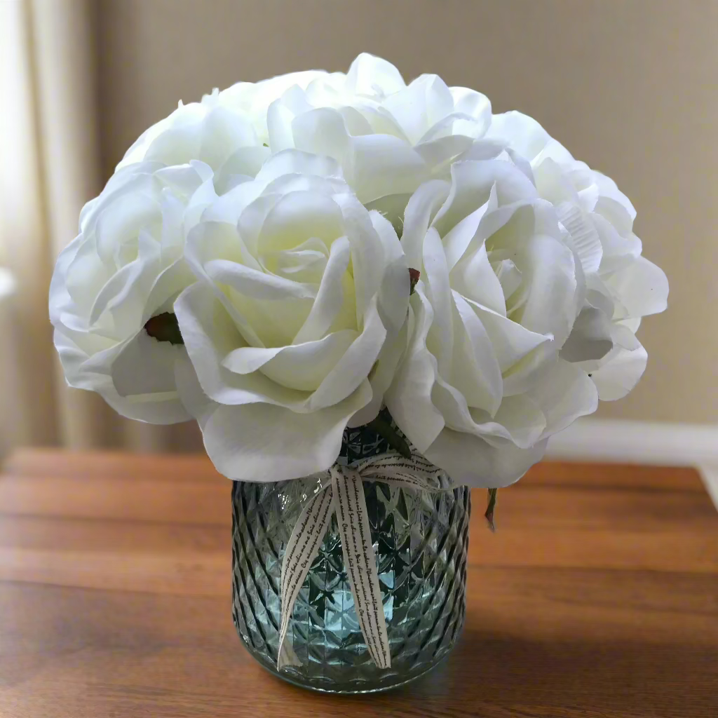 ivory faux silk flowers in blue cut glass vase