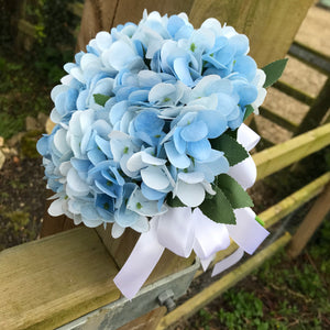 A wedding bouquet collection featuring ivory/white and pale blue flowers