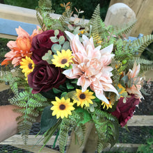 A large brides bouquet featuring dahlia, berries and roses