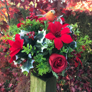 a christmas grave memorial pot with red artificial flower arrangement