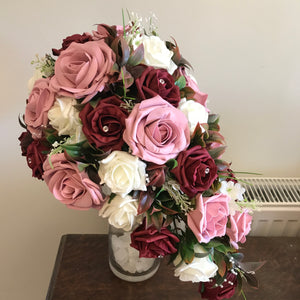 A teardrop bouquet of artificial burgundy, ivory & pink roses, crystals & pearls