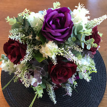 A wedding bouquet of artificial ivory & purple flowers