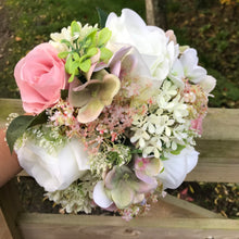 A wedding bouquet of ivory and dusky pink artificial flowers