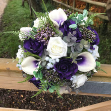 A wedding bouquet of ivory and purple silk flowers