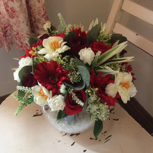 An arrangement of red and ivory flowers