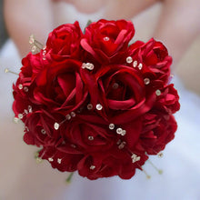 A handtied posy bouquet featuring artificial silk red roses