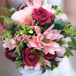 A brides bouquet of deep red, peach and burgundy roses & dahlia